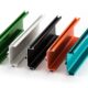 A selection of anodized aluminium profiles in various anodizing aluminium colors, including green, white, black, orange, and teal, showcasing surface finishing options.